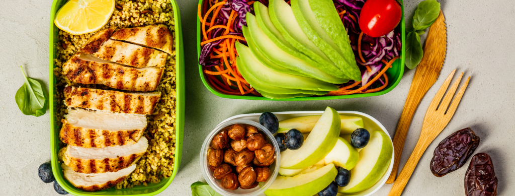 Lunch containers filled with different foods.