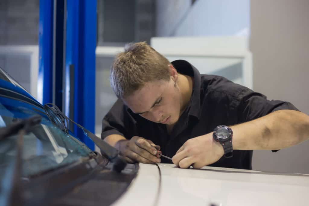 Lleyton leans over the hood of a car and words on the bonnet.