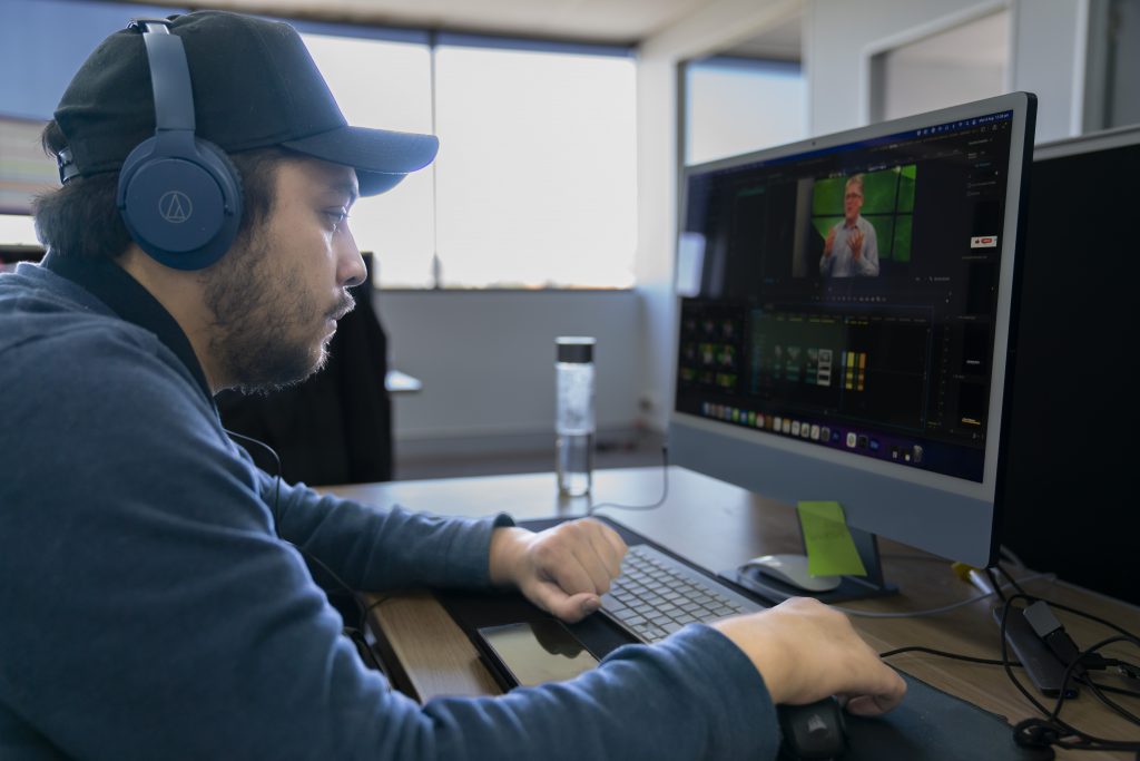 Shem works at his computer to edit videos.