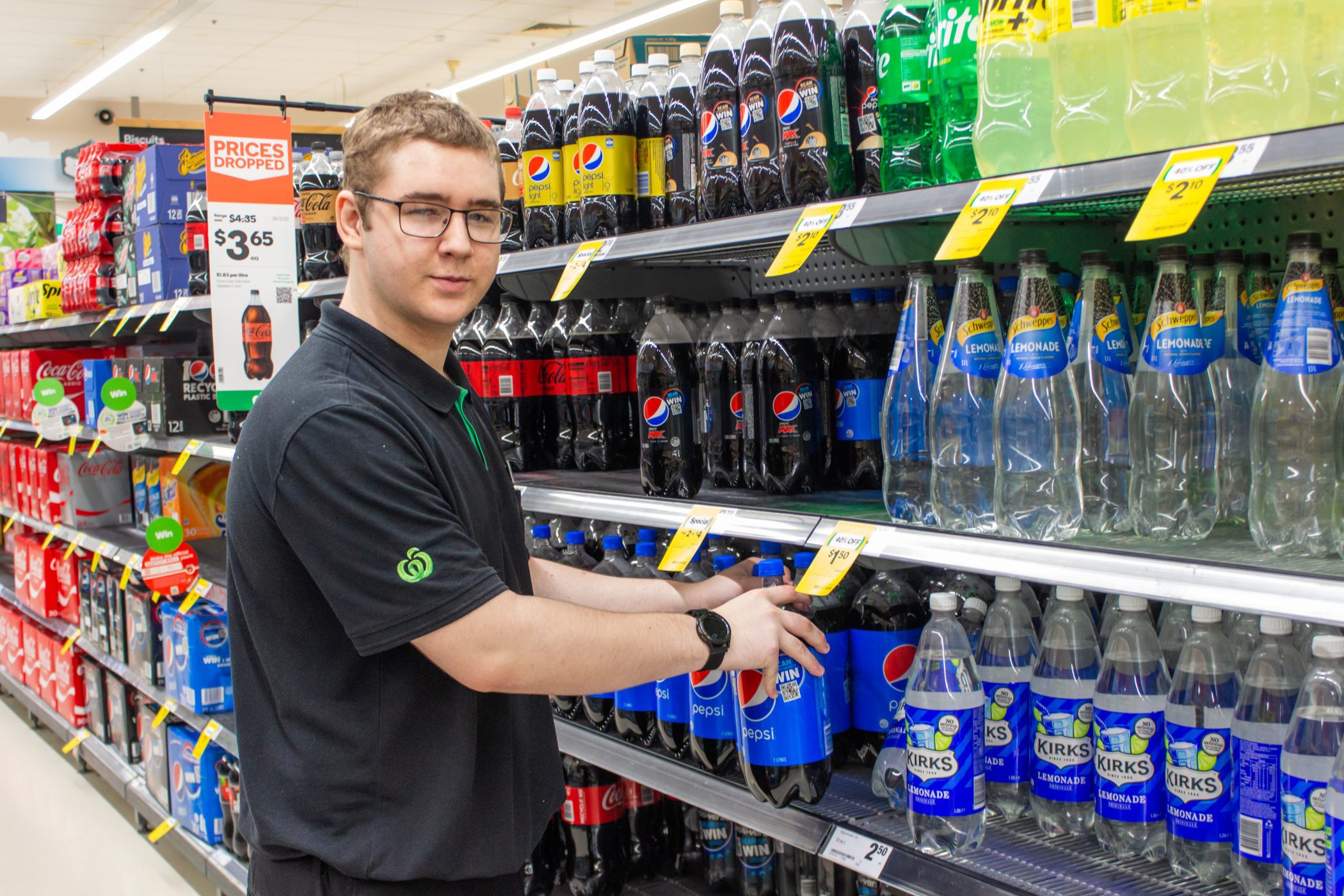 Mitchel stocking the soft drinks at Woolworths Bundaberg.