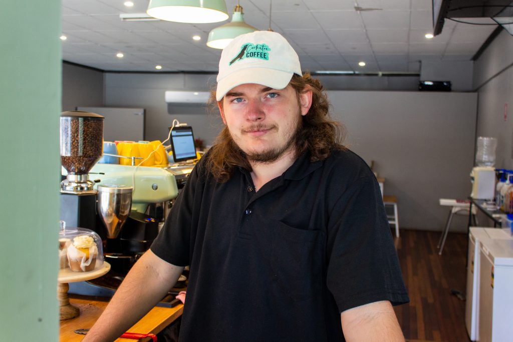 Jayden stands behind the front counter at Cockatoo Coffee