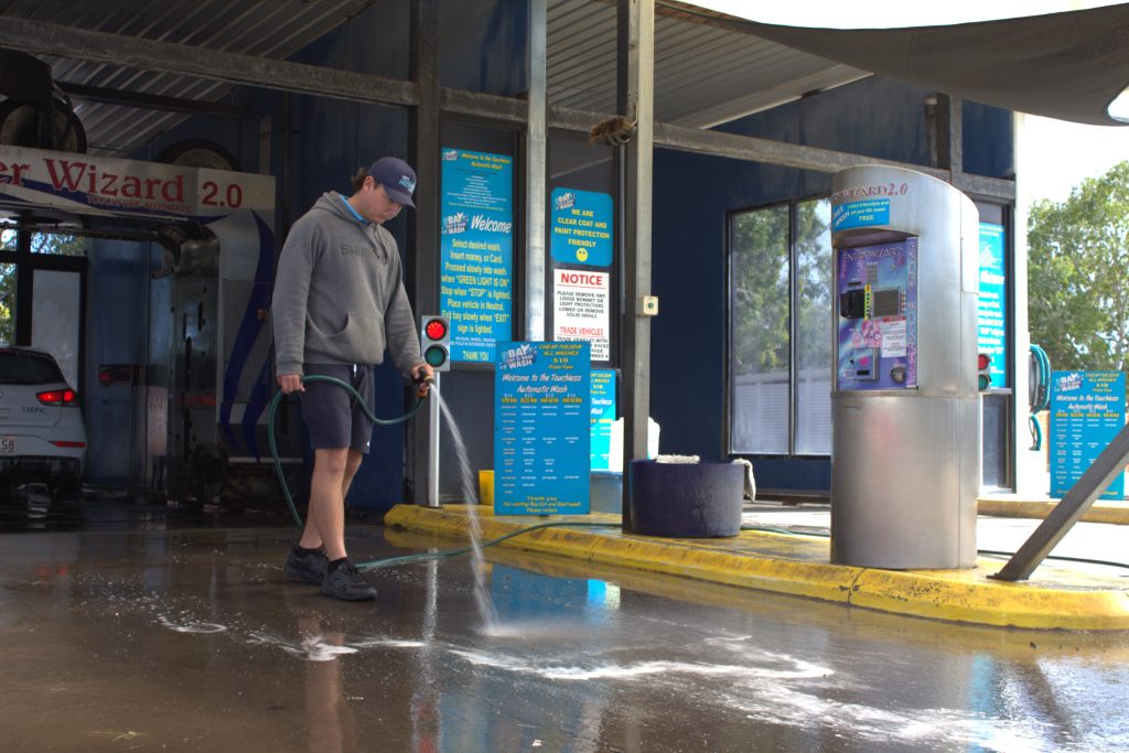 Kyah giving the car wash station a hose down.