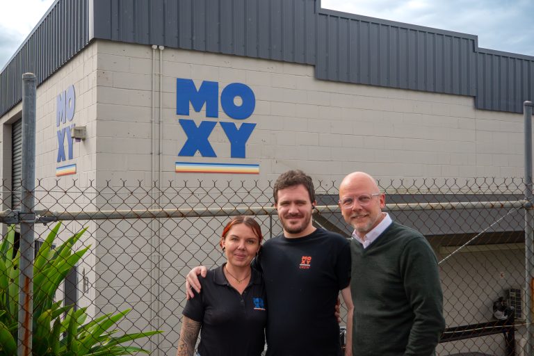 Ethan, Seonke, and Ethan's supervisor stood outside of the Moxy warehouse