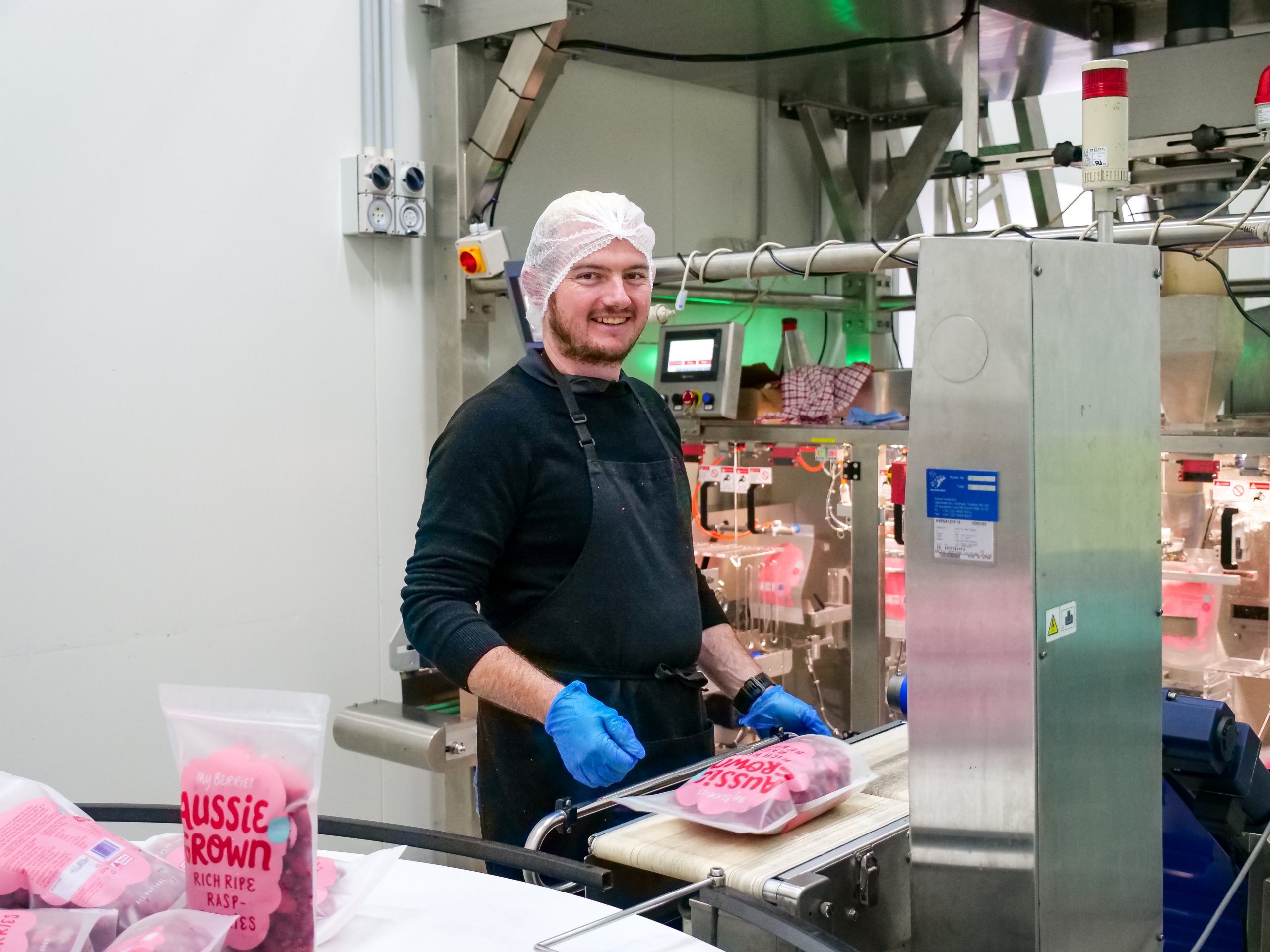Travis in the My Berries factor packaging a fresh batch of raspberries.