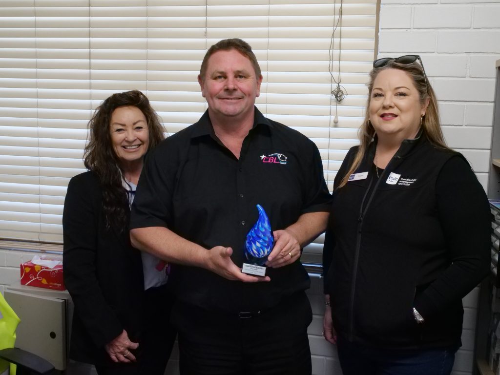 Rob stood with Robyn and Megan holding out his SERP award.